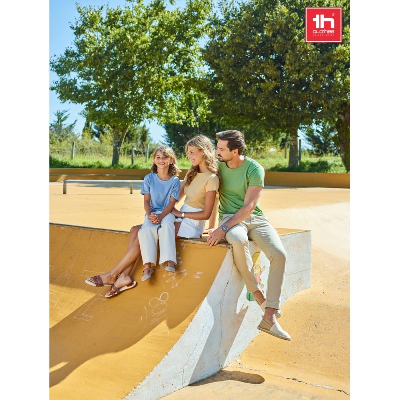Family sitting on skate park ledge, sunny day.