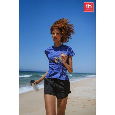 Woman jogging on beach with blue shirt