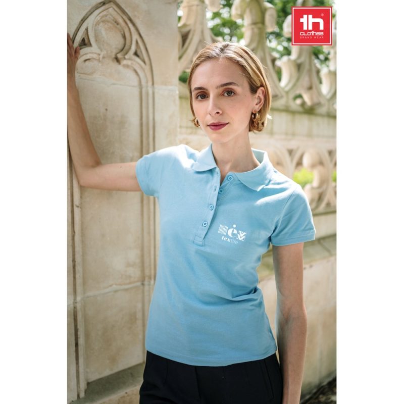 Woman wearing light blue polo shirt outdoors