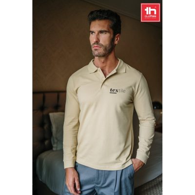 Man wearing beige long-sleeve polo shirt indoors.