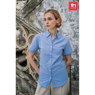 Model wearing light blue shirt, stone staircase backdrop.