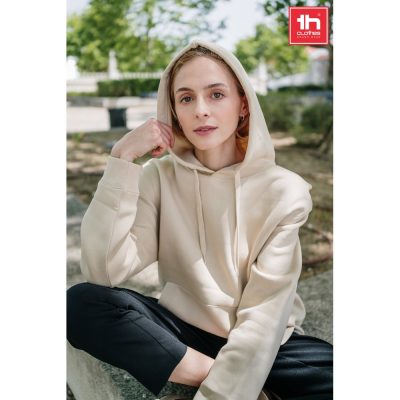 Person sitting outdoors wearing beige hoodie.