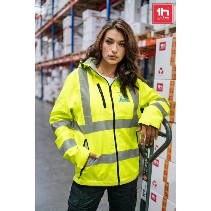 Person wearing hi-vis jacket in warehouse.