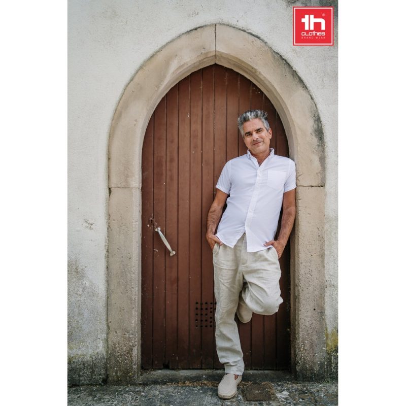 Man in casual outfit leaning against arched door