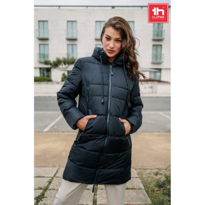 Woman wearing a long black hooded puffer coat.