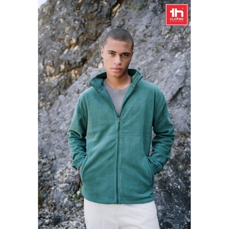 Man wearing green fleece jacket outdoors.