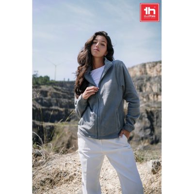 Woman in casual jacket outdoors, rocky background