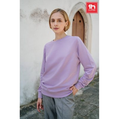 Person wearing purple sweatshirt, grey trousers.