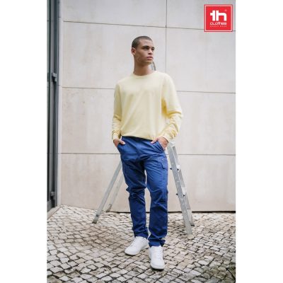 Model wearing yellow jumper and blue cargo trousers.