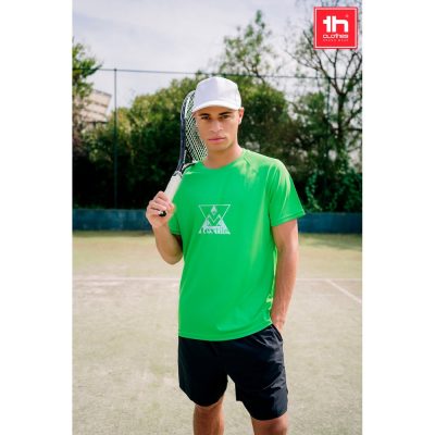 Man in green shirt holding tennis racket on court.