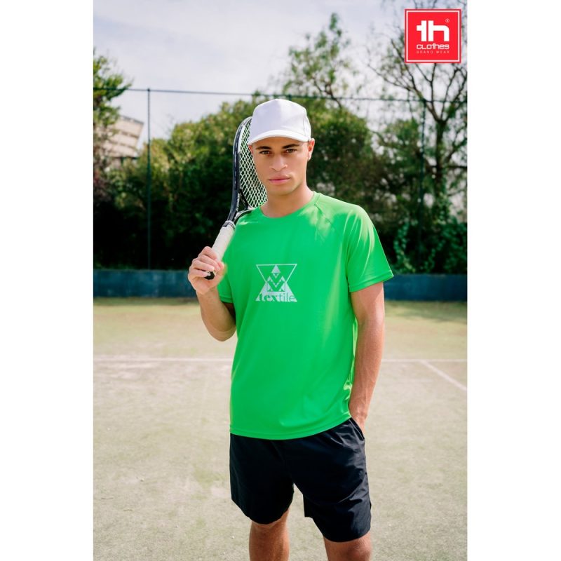 Man in green shirt holding tennis racket on court.