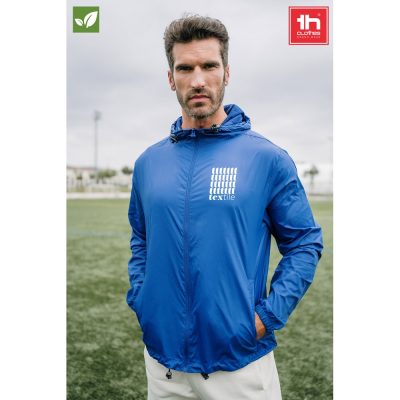 Man in blue jacket on sports field.