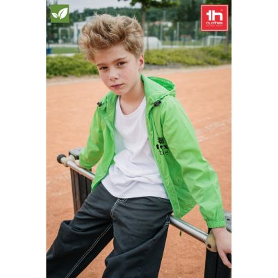 Child wearing green jacket outdoors on playground