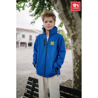 Child in blue jacket standing outdoors