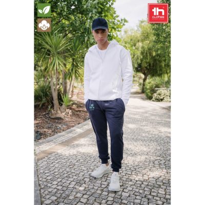 Person wearing casual clothes in a garden walkway.