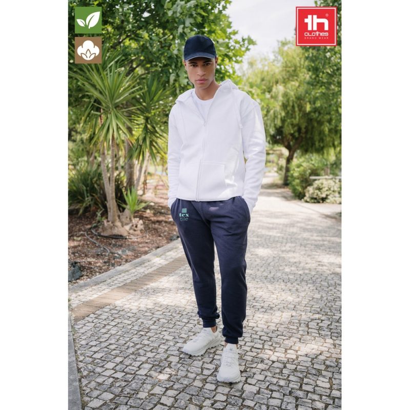 Person wearing casual clothes in a garden walkway.