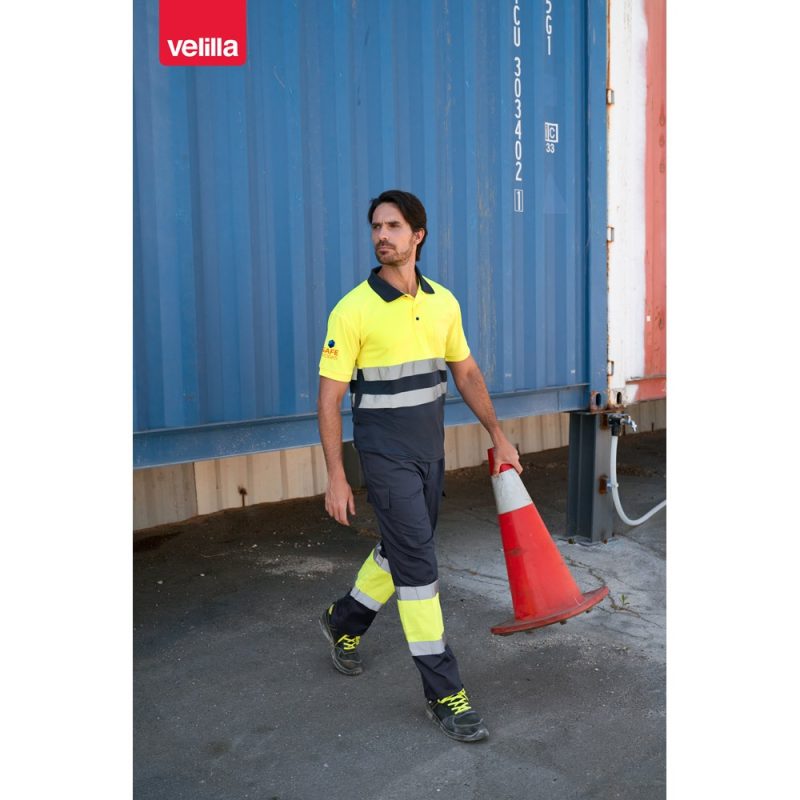 Worker in high-visibility clothing carrying traffic cone