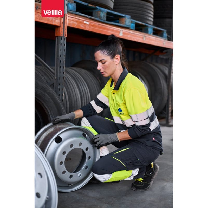 Woman inspecting industrial wheel rim in warehouse.