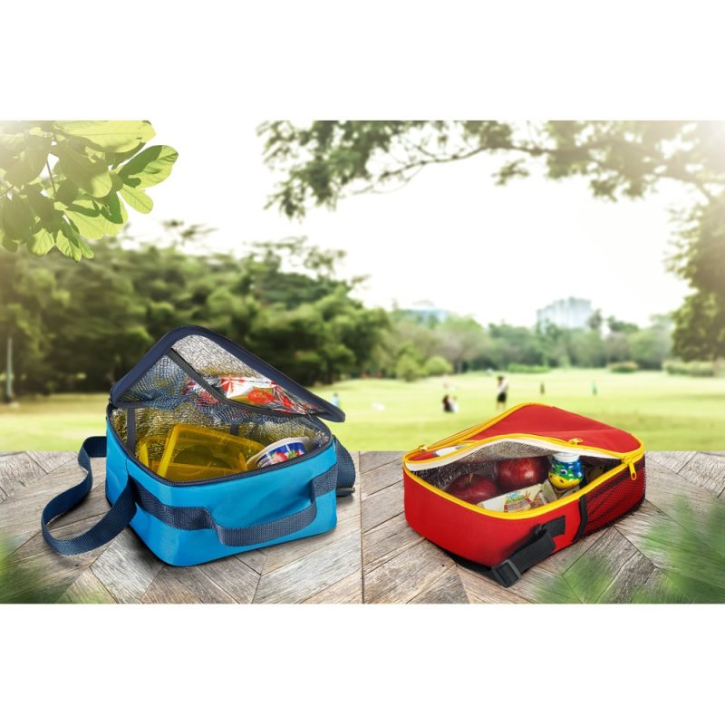 Two lunch bags with snacks on picnic table.