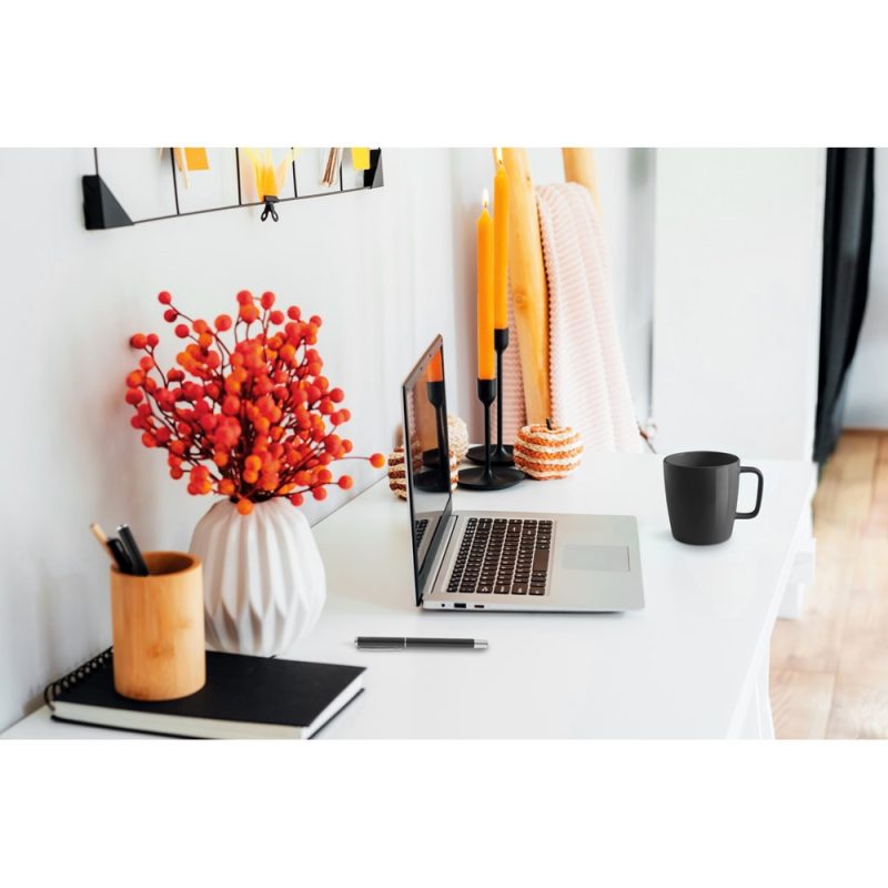 Modern desk with laptop and decorative items.