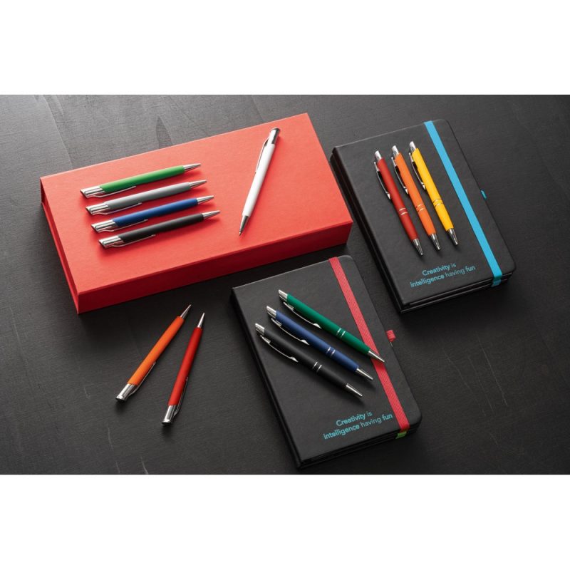 Coloured pens and notebooks on a table.