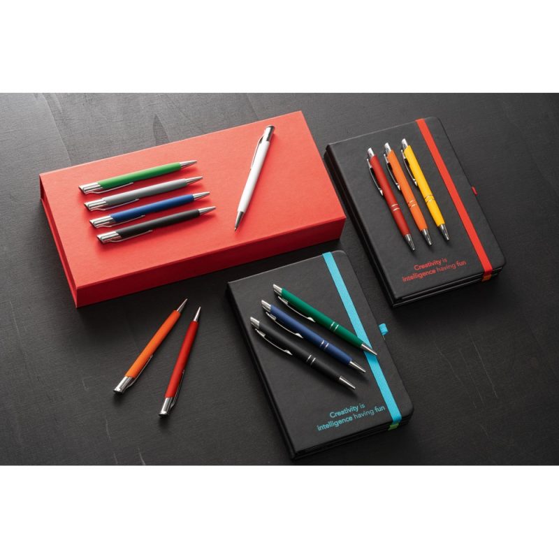 Colourful pens and notebooks on black background