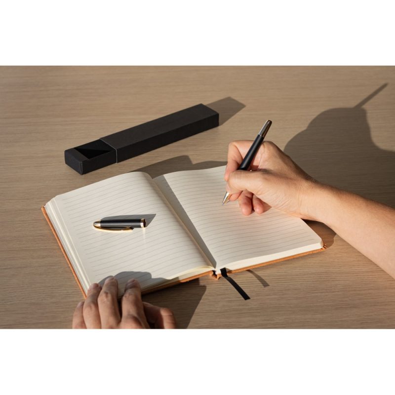 Writing in a notebook with a pen.