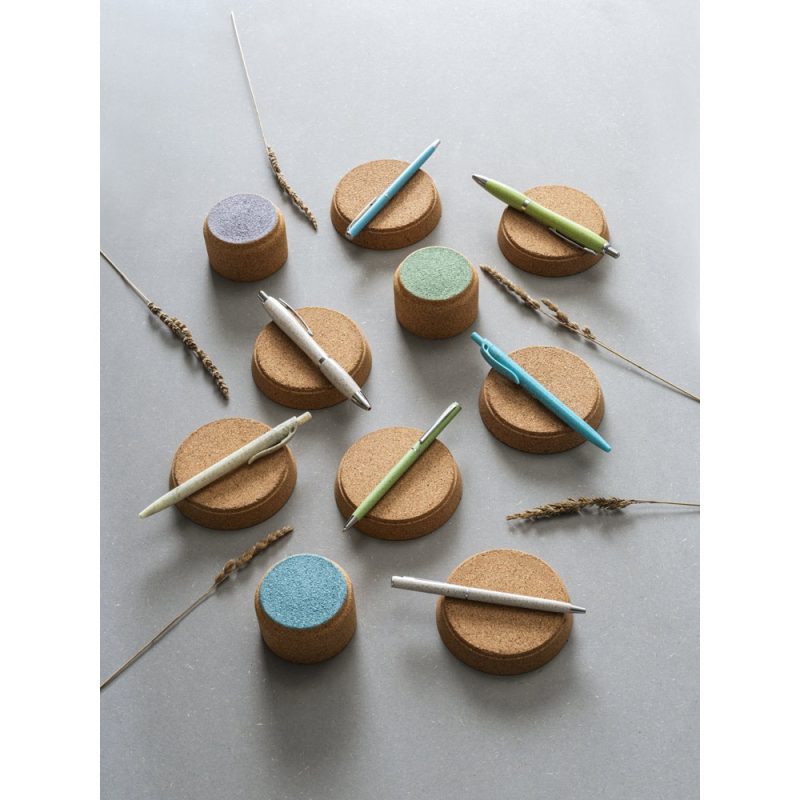Cork pen holders with assorted pens on grey background.