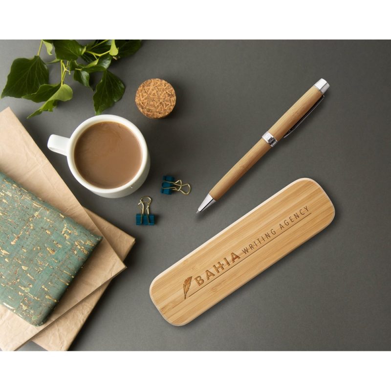 Desk with notebook, coffee, pen, and clips.