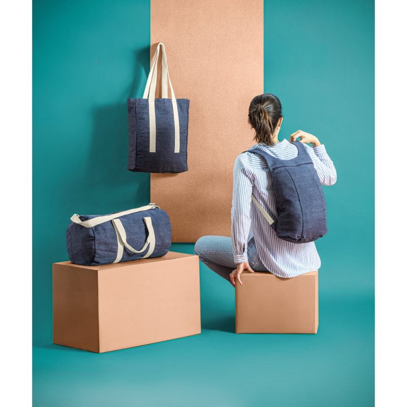 Woman with blue backpack and bags on boxes.