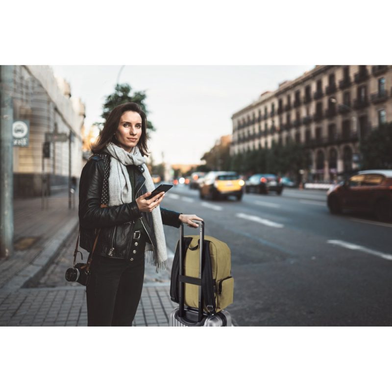 Woman traveler with luggage on city street