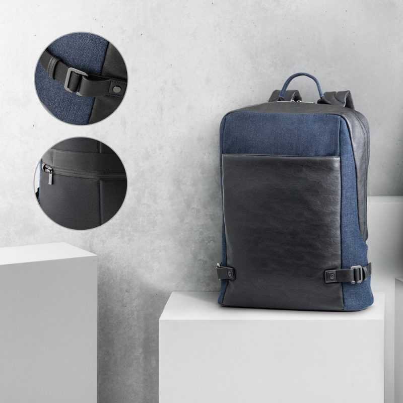 Stylish blue and black backpack on display stand.