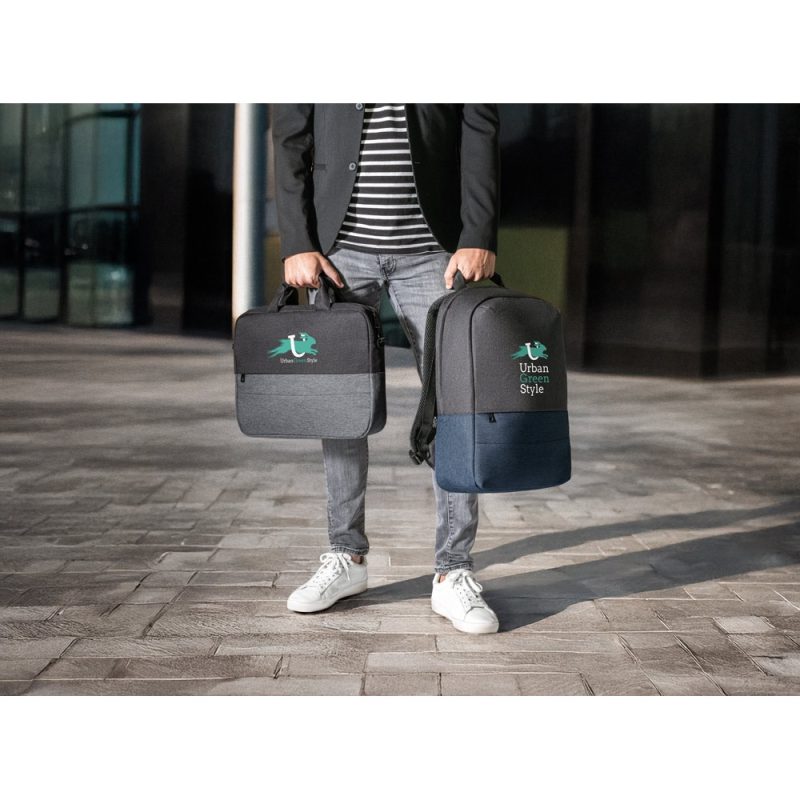 Person holding stylish urban backpacks outdoors.