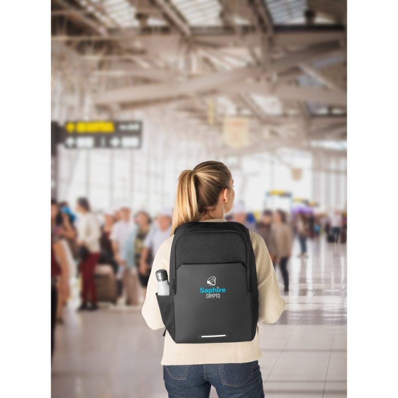 Person with backpack in busy airport terminal.