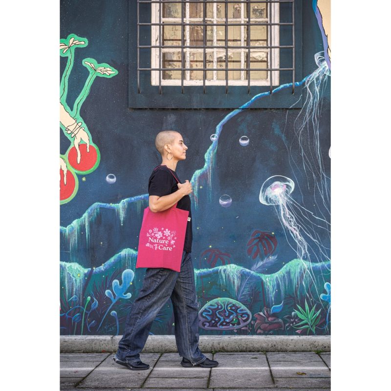 Person walking past ocean-themed graffiti wall.