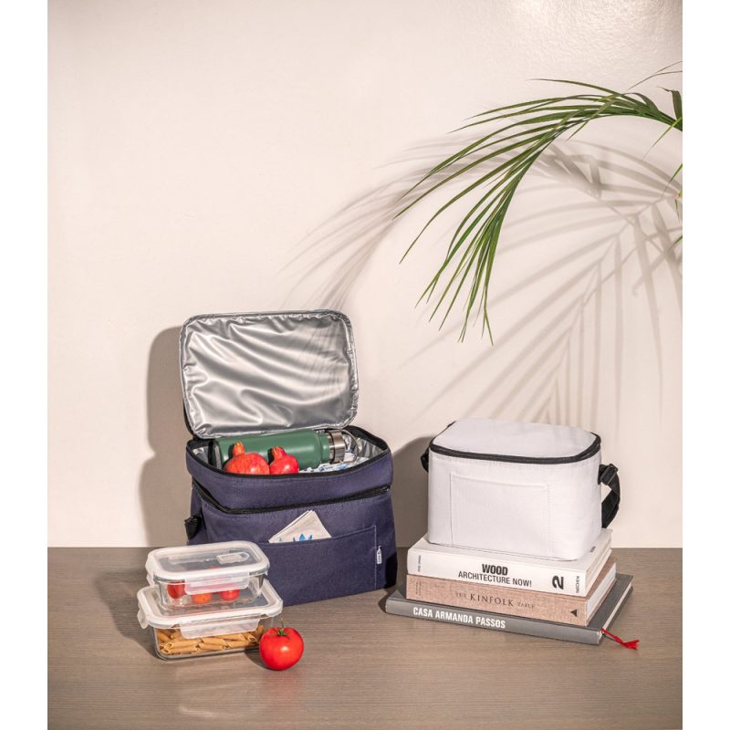 Lunch bags and food containers on table with books.
