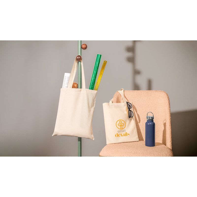 Tote bags with stationery and water bottle on chair.