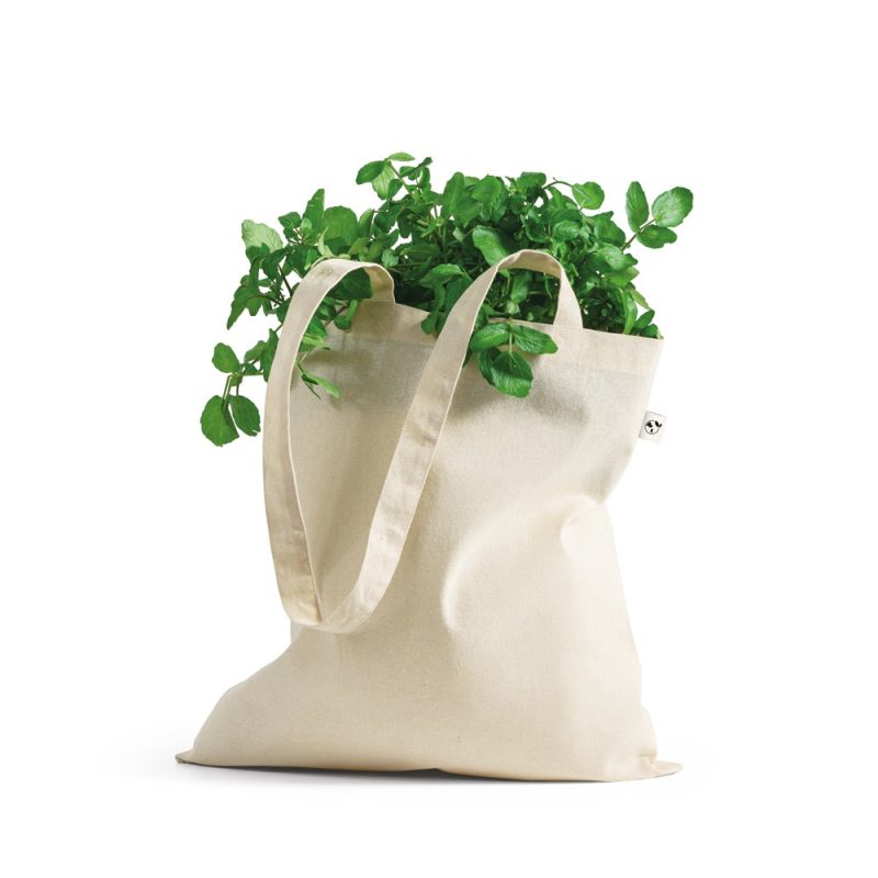 Reusable tote bag with fresh green herbs.
