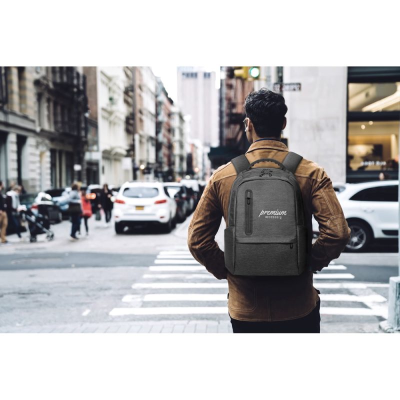 Person with backpack crossing city street