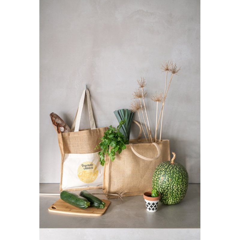 Reusable bags with vegetables and bread on table