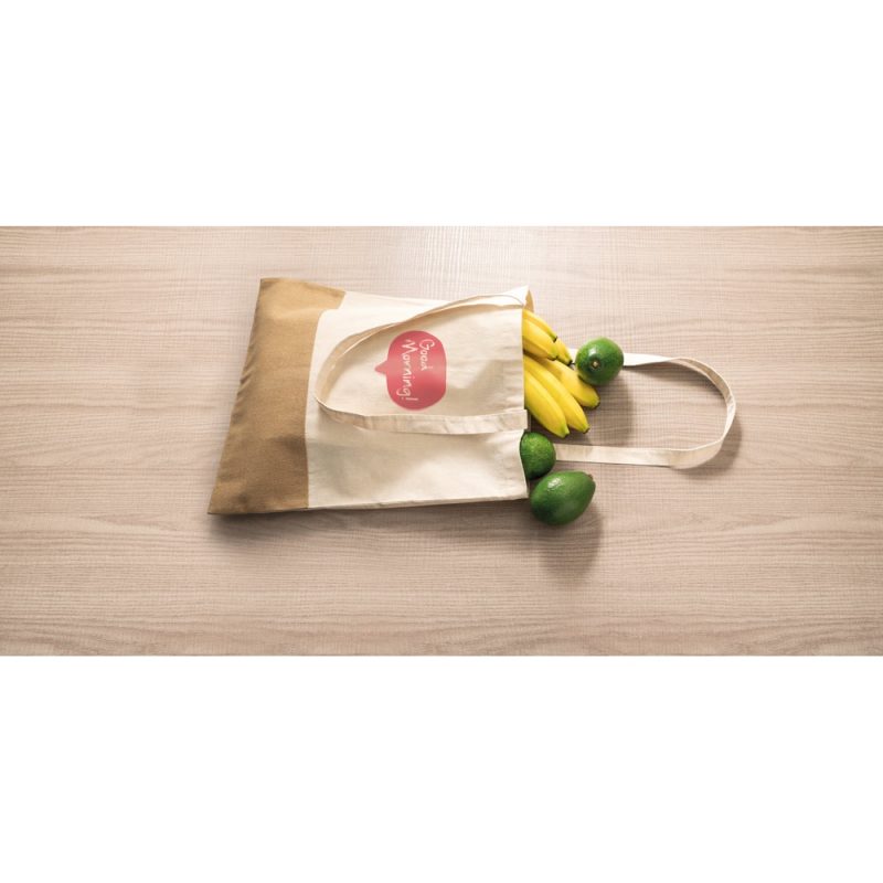 Canvas bag with bananas and avocados on table.