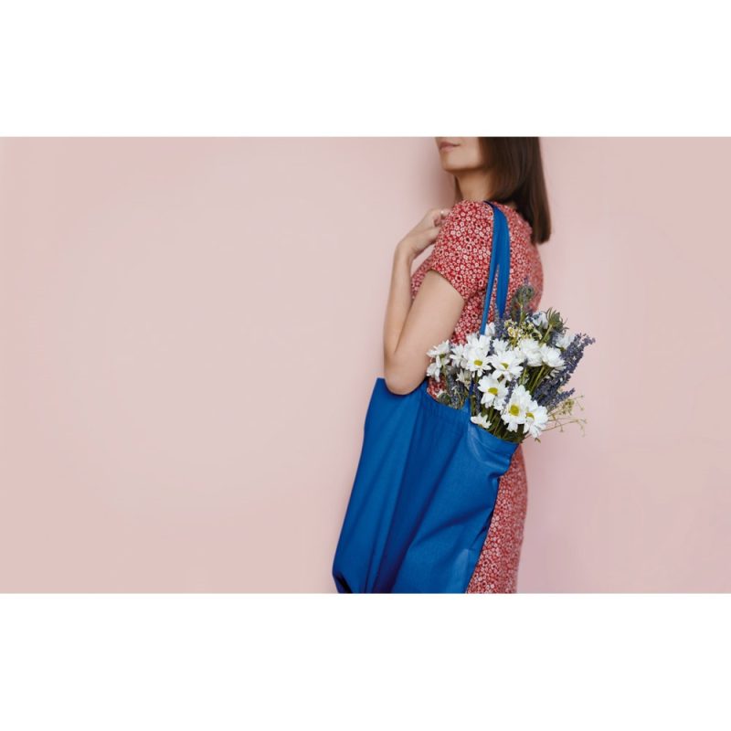 Woman holding blue bag with flowers