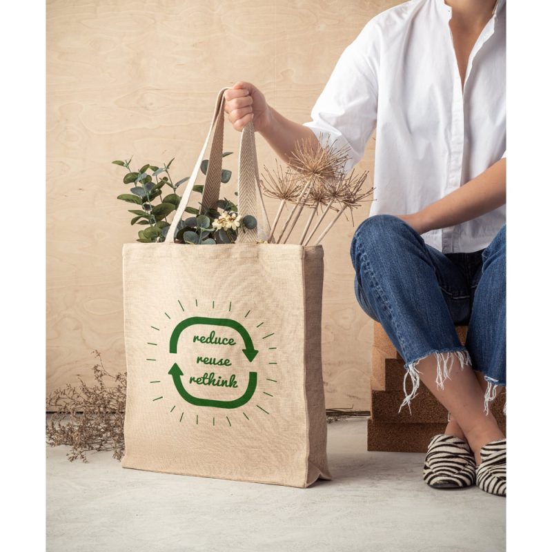 Eco-friendly bag with plants and sustainable message.