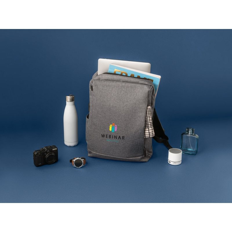 Grey rucksack surrounded by travel essentials on blue background.