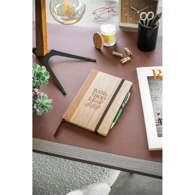 Bamboo notebook on stylish desk with accessories.