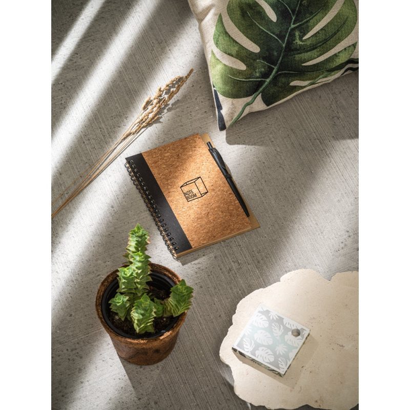 Notebook, pen, plant, pillow on concrete surface