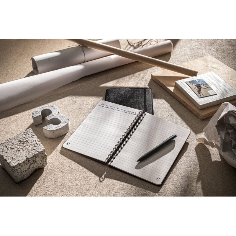 Open notebook with pen on desk, architectural tools nearby.