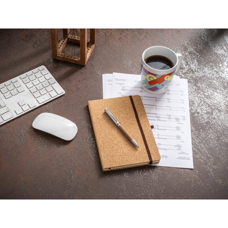Office desk with keyboard, mouse, notebook, coffee.