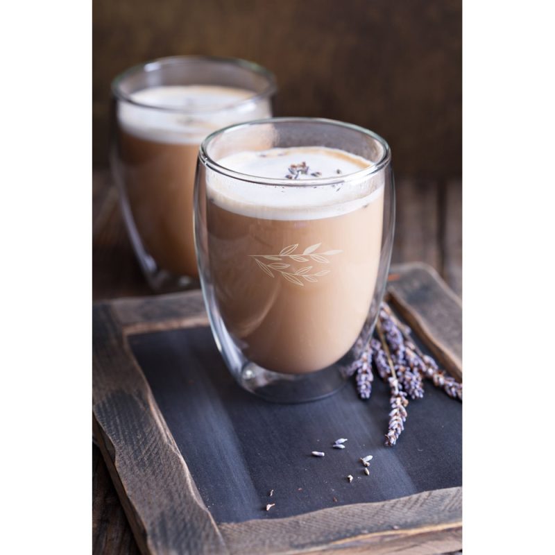 Lavender coffee latte in glass cup on tray.
