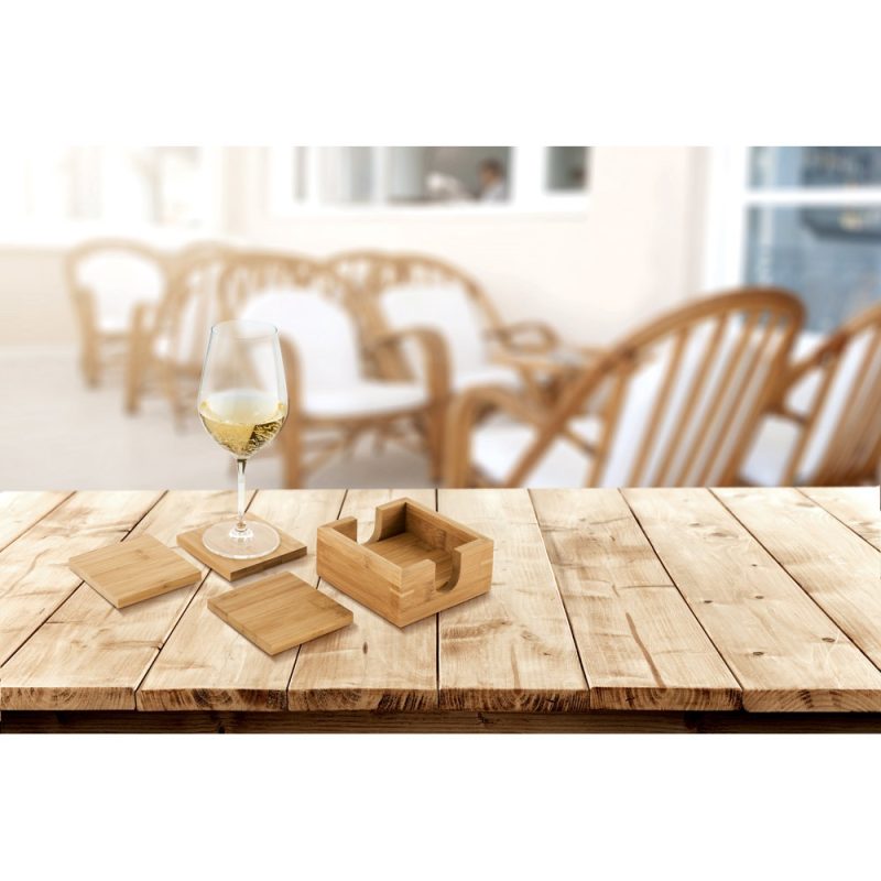 Wine glass with wooden coasters on table.